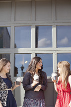 Group of women holding frozen latte drinks.