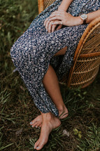 a barefoot woman with hands in her lap 