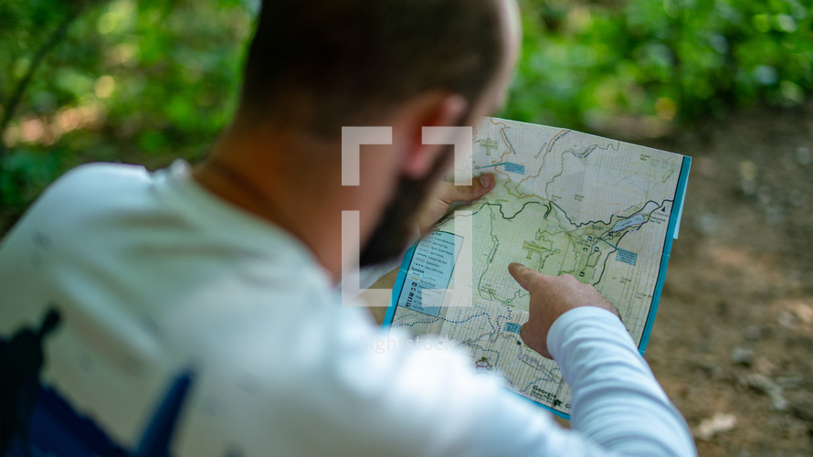a man looking at a trail map 