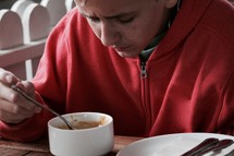 a boy eating soup 