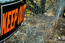 Keep Out sign on a chain link fence 