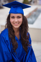 teen girl in her cap and gown at graduation 