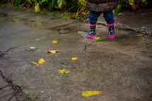 a toddler girl in rain boots 