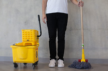a man with a mop and mop bucket 