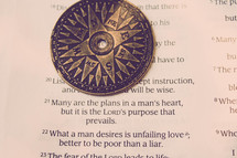 Compass on page of open Bible.