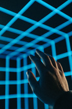 hand reaching up in 3D light cube 