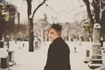 grieving woman in black in a snow covered cemetery 
