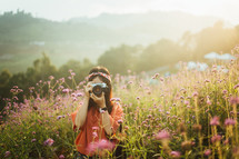 woman taking a picture in a field of flowers 