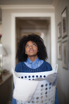 a woman holding a laundry basket looking up to God 
