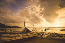 beached boats on a shore at sunrise 