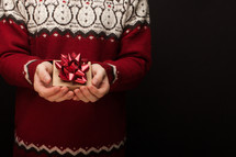 a man in Christmas sweater holding a gift box 