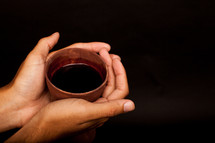 hands holding a wine chalice 
