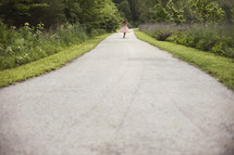 girl running down a paved path