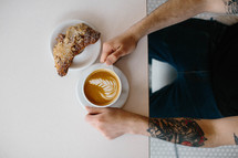 man with a pastry and coffee 