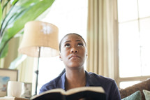 woman looking up to God while reading a Bible 