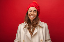 a woman in a winter coat and hat smiling 