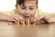 a boy counting gold coins.