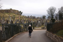 woman walking into a cemetery 