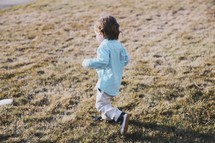 a toddler boy running outdoors 