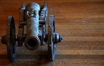 antique canon on a wood floor 