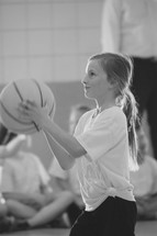 a little girl shooting a basketball 