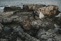 bride and groom on rocky shore 