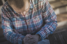 A man with hands folded in prayer