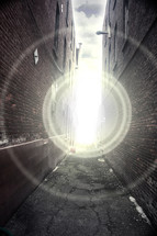 Beam of light in the alley between two buildings.