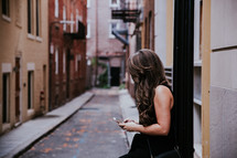 a woman texted leading against the wall in an alley 
