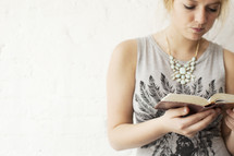 young women reading a Bible against a white background 