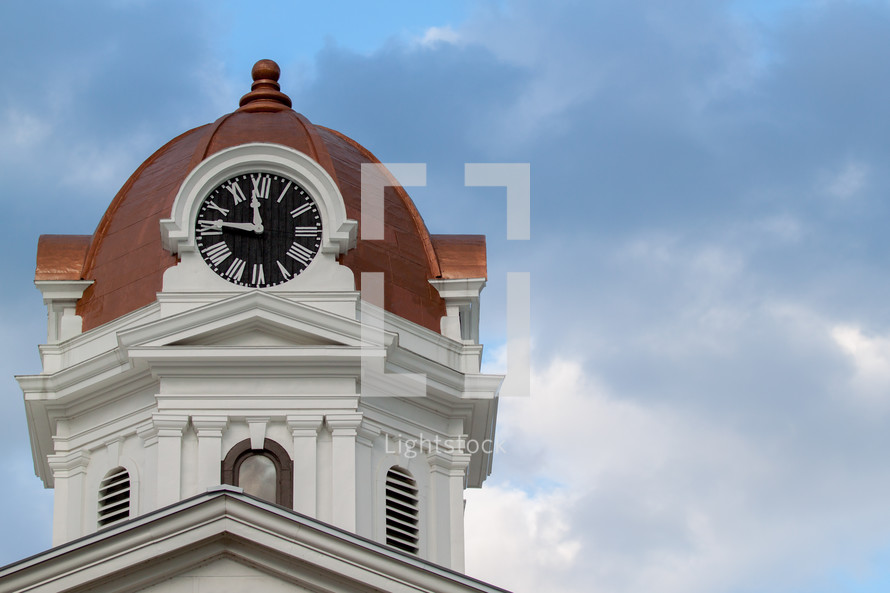 Clock on the domed tower of a church.