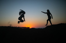 two women jumping across 