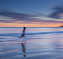 blur of a running boy on a beach 