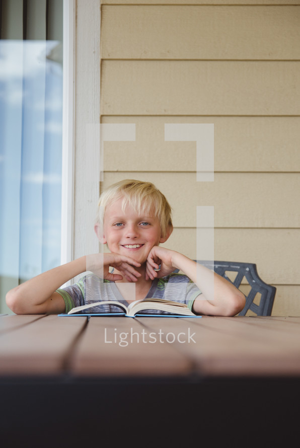 boy child reading a book outdoors 