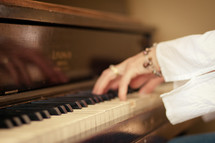 elderly woman's hands on a piano 