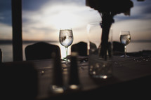 wine glasses and place settings on a table under low light