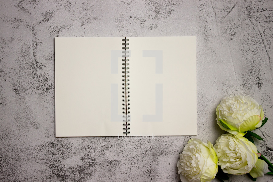 Notebook on concrete counter with flowers