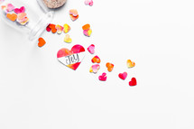 Top view of watercolor hearts scattered on white background with one labeled JOY. 