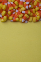 border of candy corn on a yellow background 