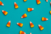 scattered candy corns on a blue background 