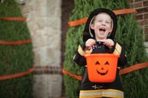 a boy child in a fire fighter costume trick-or-treating 