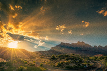 rays of sunlight behind mountains at sunrise 