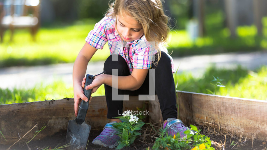 girl child digging in a garden 