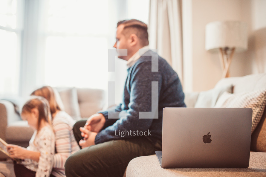 a family watching a worship service at home on their TV