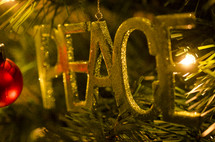 PEACE ornament hanging on a Christmas tree