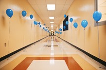 A hallway lined with blue balloons.