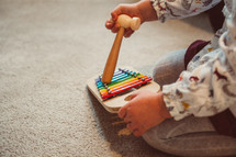 child playing with toys on the carpet 