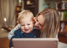 a mother and child making a video call on a laptop 