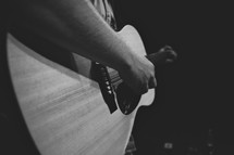 hand playing an acoustic guitar