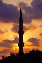 silhouette of a tower on a mosque at sunset